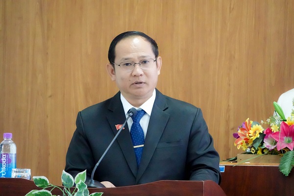 A person in a suit and tie speaking at a podiumDescription automatically generated